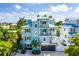Aerial view of a three-story, light blue home with multiple balconies and a brown garage door at 336 Avenida De Mayo, Sarasota, FL 34242