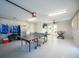 Spacious game room with ping pong table, foosball table, television, and garage door access at 336 Avenida De Mayo, Sarasota, FL 34242