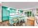 Bright, cheerful kitchen features custom turquoise cabinetry, long island with seating, and sliding glass doors at 336 Avenida De Mayo, Sarasota, FL 34242