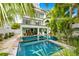 Stunning backyard pool with covered outdoor dining and lounge area, surrounded by tropical plants at 336 Avenida De Mayo, Sarasota, FL 34242