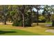 Picturesque golf course with lush green fairways, mature trees, and a serene pond, offering a challenging play at 3424 Hadfield Greene # 17, Sarasota, FL 34235