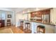 Modern kitchen bar featuring stainless steel appliances, wood cabinets, granite countertops, and bar stool seating at 3455 Flamingo Ave, Sarasota, FL 34242