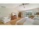 Bright main bedroom featuring a ceiling fan, wooden floors, neutral walls, and balcony access at 3455 Flamingo Ave, Sarasota, FL 34242