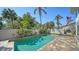 A crystal clear swimming pool surrounded by lush greenery and a privacy wall at 3455 Flamingo Ave, Sarasota, FL 34242