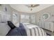 This bedroom features a coastal decor, ceiling fan, and large windows with plantation shutters at 3568 Santa Caterina Blvd, Bradenton, FL 34211