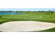 View of the beautiful golf course with sand trap in the foreground and lake behind it at 3568 Santa Caterina Blvd, Bradenton, FL 34211