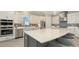 Modern kitchen boasting white cabinetry, stainless steel appliances, island with seating and quartz countertops at 3568 Santa Caterina Blvd, Bradenton, FL 34211