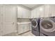 Well-equipped laundry room with sink, storage cabinets, and modern washer and dryer at 3568 Santa Caterina Blvd, Bradenton, FL 34211