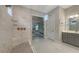 This main bathroom features a large shower with a glass door and a grey vanity at 3568 Santa Caterina Blvd, Bradenton, FL 34211