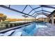 Gorgeous pool with a spa, sun loungers, and a serene golf course view in a screened-in lanai at 3568 Santa Caterina Blvd, Bradenton, FL 34211