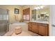 Bright bathroom featuring a soaking tub, walk-in shower, shuttered window, and a double sink vanity with granite countertops at 3752 Summerwind Cir, Bradenton, FL 34209