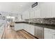 Modern kitchen features sleek white cabinetry, stainless steel appliances, backsplash, and a view of the dining area at 3752 Summerwind Cir, Bradenton, FL 34209