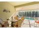 A covered lanai features outdoor seating, a built-in grill, and a view of the screened-in pool and spa at 3752 Summerwind Cir, Bradenton, FL 34209