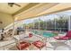 Outdoor seating surrounds a patio table on the covered lanai, with a barbecue grill and views of the pool at 3752 Summerwind Cir, Bradenton, FL 34209