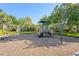 Community playground with climbing structure, slide, and lush, mature trees at 3752 Summerwind Cir, Bradenton, FL 34209