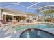 Backyard view of pool and spa surrounded by outdoor seating and landscaping, with access to the home's covered patio at 3752 Summerwind Cir, Bradenton, FL 34209
