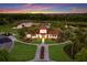 Aerial view of a clubhouse surrounded by lush landscaping, a pool, a lake and winding sidewalk trails at 3814 Scrub Creek Run, Lakewood Ranch, FL 34211
