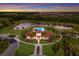A scenic aerial view showcases a community clubhouse with a pool and a calm lake surrounded by a nature preserve at 3814 Scrub Creek Run, Lakewood Ranch, FL 34211