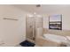 Bright bathroom with a glass-enclosed shower, soaking tub, and large window offering plenty of natural light at 3814 Scrub Creek Run, Lakewood Ranch, FL 34211