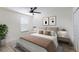Bright bedroom featuring a queen-sized bed, neutral decor, and a ceiling fan at 3814 Scrub Creek Run, Lakewood Ranch, FL 34211