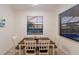 Cozy dining area featuring a wooden table with four chairs and natural light from the window at 3814 Scrub Creek Run, Lakewood Ranch, FL 34211