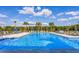 Large community pool with lots of seating and palm trees at 3814 Scrub Creek Run, Lakewood Ranch, FL 34211