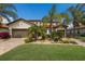 Two story home with a two-car garage, stone accents, brick paver driveway, and manicured landscaping at 3814 Scrub Creek Run, Lakewood Ranch, FL 34211