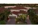 Expansive two-story home featuring a red tile roof, a three-car garage and lush tropical landscaping at 3814 Scrub Creek Run, Lakewood Ranch, FL 34211