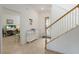 Bright foyer featuring tile floors, a console table, and a staircase with wooden handrail at 3814 Scrub Creek Run, Lakewood Ranch, FL 34211