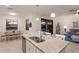 Bright, open-concept kitchen featuring an island with seating, modern appliances, and a view of the living room at 3814 Scrub Creek Run, Lakewood Ranch, FL 34211