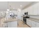 Spacious kitchen with white cabinets, granite countertops, stainless steel appliances, and breakfast bar at 3814 Scrub Creek Run, Lakewood Ranch, FL 34211