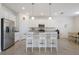 Bright kitchen with white cabinets, stainless steel appliances, and a granite countertop island with seating at 3814 Scrub Creek Run, Lakewood Ranch, FL 34211