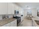 Well-lit kitchen featuring stainless steel appliances, granite countertops, and an adjacent dining area at 3814 Scrub Creek Run, Lakewood Ranch, FL 34211