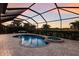 Secluded screened-in pool with heated spa, spacious deck, lush landscaping, and a peaceful view of the lake at 3814 Scrub Creek Run, Lakewood Ranch, FL 34211