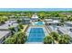 Aerial view featuring the tennis court and community pool with lush landscaping and residential buildings at 4001 Beneva Rd # 343, Sarasota, FL 34233
