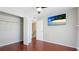 Bright bedroom features wood floors, ceiling fan, and TV screen with tropical beach scene displayed at 4001 Beneva Rd # 343, Sarasota, FL 34233