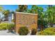 Community entrance sign displaying Beneva Ridge, surrounded by lush tropical landscaping on a sunny day at 4001 Beneva Rd # 343, Sarasota, FL 34233