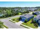 Aerial view of a light blue single-Gathering home with lush landscaping in a well-maintained neighborhood near a pond at 4107 Pine Meadow Dr, Parrish, FL 34219