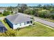 Aerial view of a light blue home on a green, landscaped lot with a view of a lake and surrounding neighborhood at 4107 Pine Meadow Dr, Parrish, FL 34219