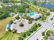 Stunning aerial view of the community featuring a pool, clubhouse, tennis courts, and ample parking at 4107 Pine Meadow Dr, Parrish, FL 34219