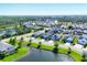 Aerial view of a neighborhood with pond; showcasing well-maintained landscaping and mature trees at 4107 Pine Meadow Dr, Parrish, FL 34219