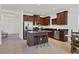 Modern kitchen with cherry wood cabinets, granite countertops, stainless steel appliances, and island seating at 4107 Pine Meadow Dr, Parrish, FL 34219