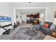 Bright open-concept living room featuring modern decor, flows into kitchen with breakfast bar and stainless steel appliances at 4107 Pine Meadow Dr, Parrish, FL 34219