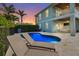 Backyard view of the pool area with lounge chairs, illuminated pool, and covered patio at 4109 Cobia Ct, Palmetto, FL 34221