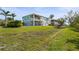 Spacious backyard with a lush green lawn complemented by palm trees and a neighboring building at 4109 Cobia Ct, Palmetto, FL 34221
