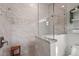 Bright bathroom featuring a glass shower, marble tile walls, and a wooden stool at 4109 Cobia Ct, Palmetto, FL 34221