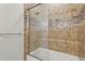 Modern bathroom shower with brown tiling, glass door, and a bathtub at 4109 Cobia Ct, Palmetto, FL 34221