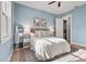 Bright and airy bedroom with a ceiling fan, light blue walls, and a view into the bathroom at 4109 Cobia Ct, Palmetto, FL 34221