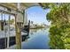 Scenic view of a boat dock showcasing a boat lift and calm waters amidst lush green foliage at 4109 Cobia Ct, Palmetto, FL 34221