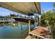 View of a boat and lift on a covered dock with wood deck near the water, creating a serene waterfront setting at 4109 Cobia Ct, Palmetto, FL 34221